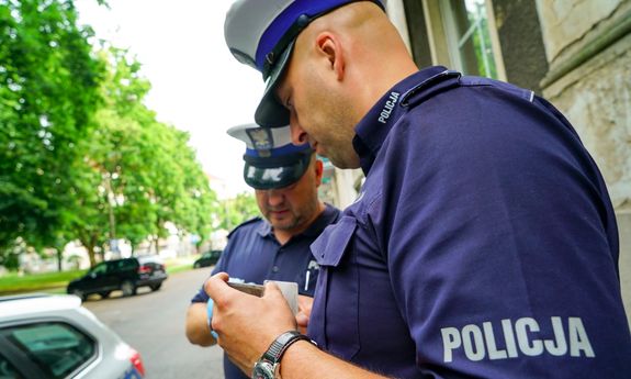 policjanci prowadzą czynności na miejscu wypadku drogowego