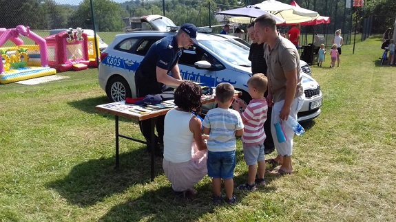 policjant rozdaje materiały informacyjne akcji Kręci mnie bezpieczeństwo nad wodą
