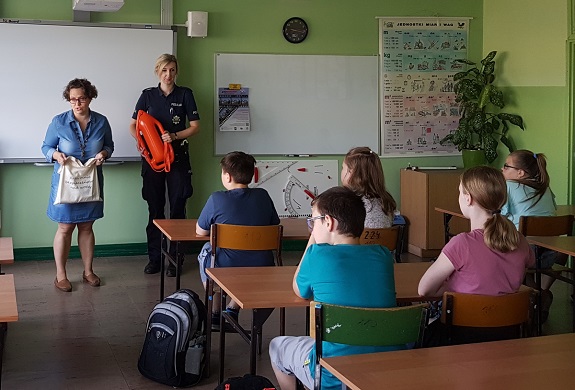 policjantka pokazuje dzieciom gadżety przygotowane do akcji Kręci mnie bezpieczeństwo nad wodą