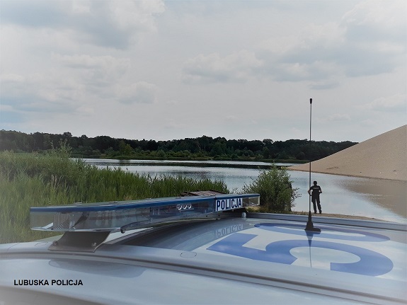 policjant obserwuje bezpieczeństwo nad zbiornikiem wodnym