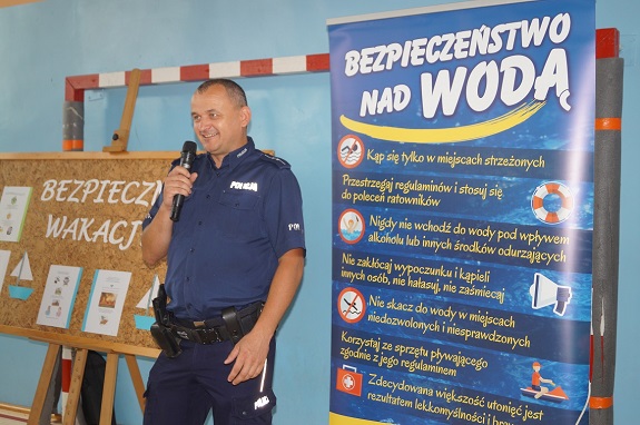 policjant przekazuje zasady bezpiecznego zachowania nad wodą