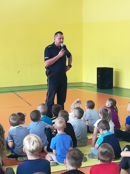 policjant przekazuje dzieciom zasady bezpiecznego zachowania nad wodą