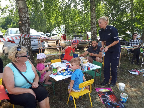 Policjantka przekazuje dzieciom zasady bezpiecznego zachowania nad wodą