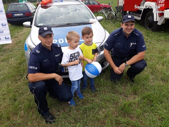 policjanci rozdają dzieciom gadżety akcji Kręci mnie bezpieczeństwo nad wodą