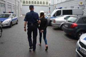 zatrzymana kobieta prowadzona przez policjanta