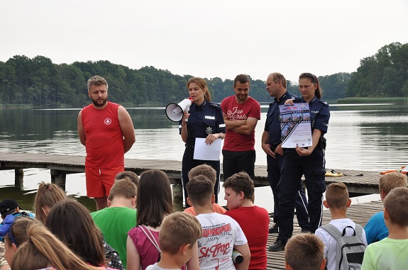 policjanci przekazują dzieciom zasady bezpiecznego zachowania nad wodą
