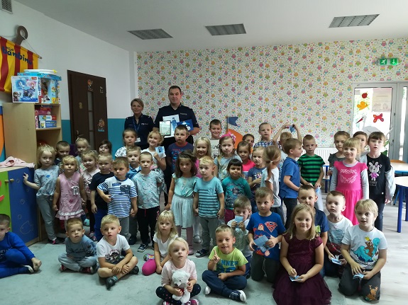 policjant przekazuje dzieciom zasady bezpiecznego zachowania nad wodą
