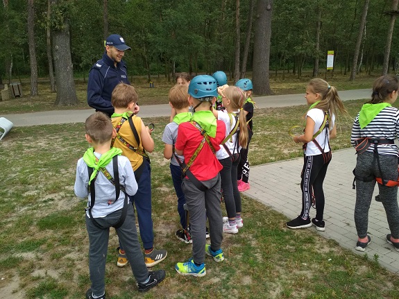 policjant przekazuje dzieciom zasady bezpiecznego zachowania nad wodą