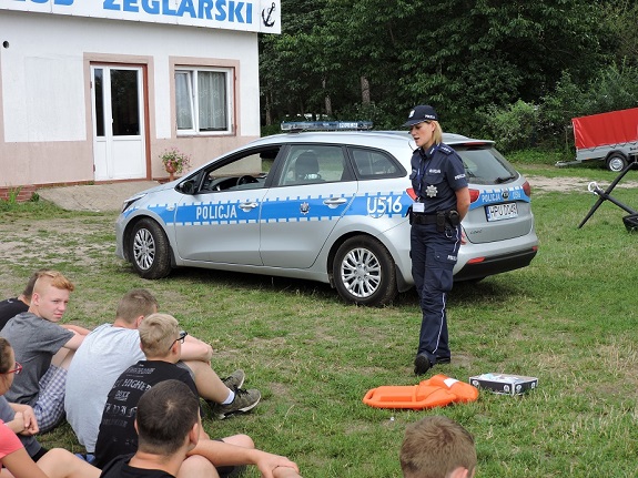 policjantka przekazuje dzieciom zasady bezpiecznego zachowania nad wodą