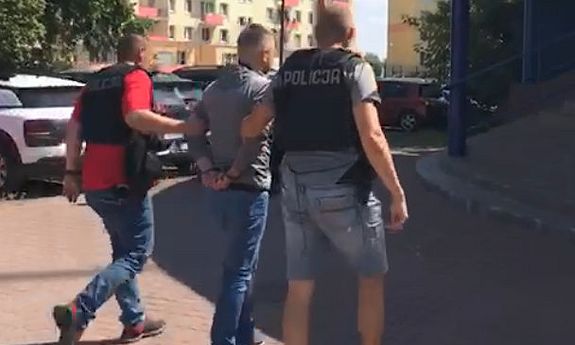 policjanci prowadzą zatrzymanego