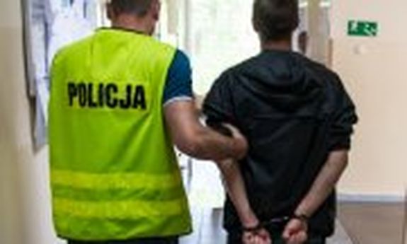 policjant prowadzi zatrzymanego