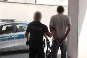 policjanci prowadzą zatrzymanego