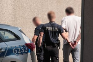 policjanci prowadzą zatrzymanego