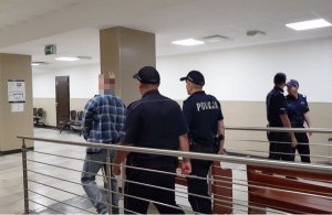 policjanci prowadzą zatrzymanego