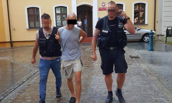 policjanci prowadzą zatrzymanego