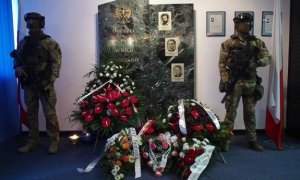 Policjanci Biura Operacji Antyterrorystycznych pełnią wartę przy tablicy upamiętniającej poległych kolegów