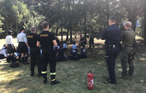 Policjanci wspólnie ze strażakami przekazują dzieciom zasady bezpiecznego zachowania nad wodą.