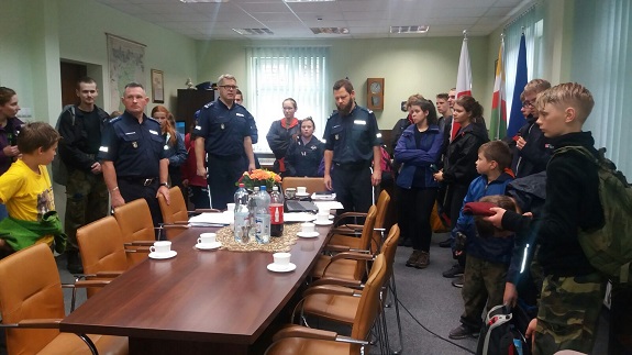 Policjanci wspólnie z dziećmi rozmawiają o bezpieczeństwie nad wodą.