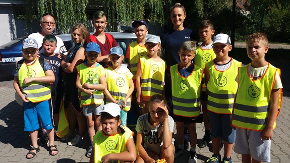 Policjantka przekazuje dzieciom zasady bezpiecznego zachowania nad wodą.
