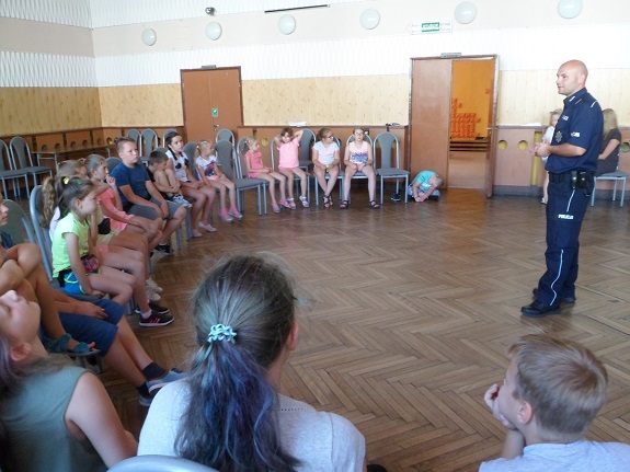 Policjant przekazuje zasady bezpiecznego zachowania nad wodą.