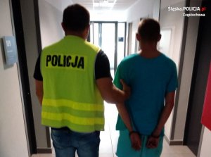 policjant prowadzi zatrzymanego