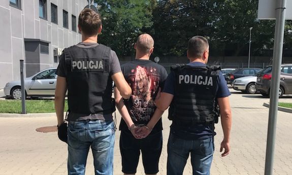 policjanci prowadzą zatrzymanego