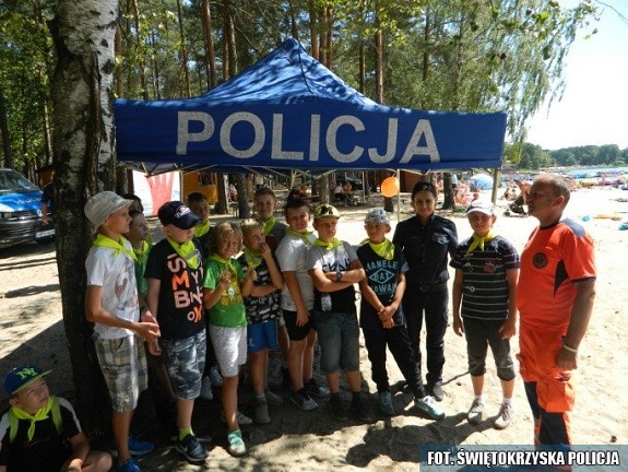Policjanci wspólnie z ratownikami medycznymi przekazują dzieciom zasady bezpiecznego zachowania nad wodą.