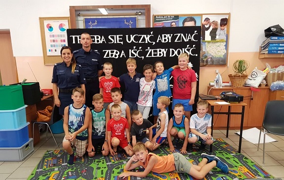 Policjanci przekazują dzieciom zasady bezpiecznego zachowania nad wodą.