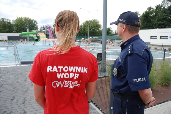 Policjant wspólnie z Panią ratownik obserwują bezpieczeństwo nad wodą.