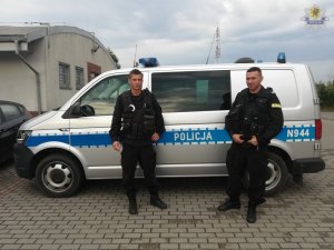 dwaj policjanci przy radiowozie