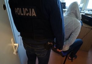 policjant z zatrzymanym mężczyzną