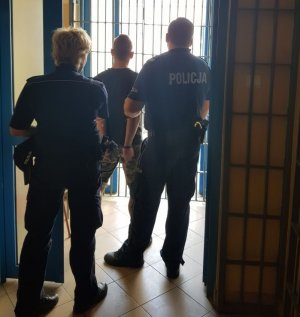 policjanci prowadzą zatrzymanego