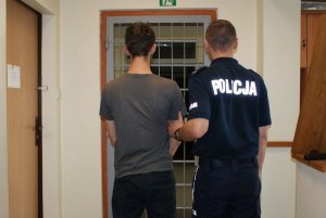 policjant prowadzi zatrzymanego