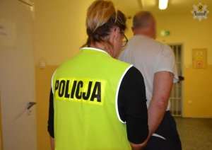 policjantka prowadzi zatrzymanego