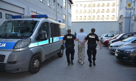 policjanci prowadzą zatrzymanego