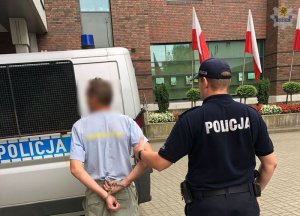 policjant prowadzi zatrzymanego