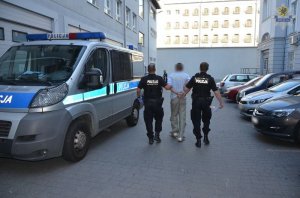 policjanci prowadzą zatrzymanego