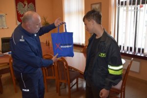 Komendant Powiatowy Policji w Tarnowskich Górach mł. insp. Krzysztof Hajda dziękuje młodemu bohaterowi za odnalezienie zaginionego seniora