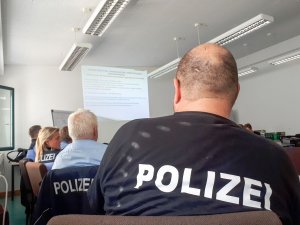 Grupa osób znajduje się na sali konferencyjnej, w tym niemieccy policjanci.