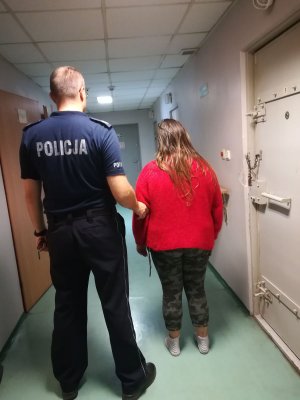 policjant prowadzi zatrzymaną