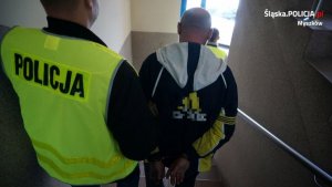policjant prowadzi zatrzymanego