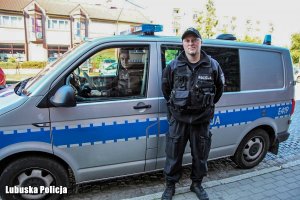 policjant stoi przy radiowozie drugi siedzi w środku