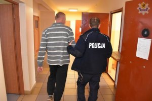 policjant prowadzi zatrzymanego