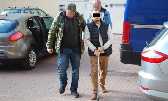 policjant prowadzi zatrzymanego