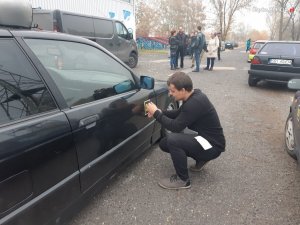mężczyzna przykleja naklejkę na auto