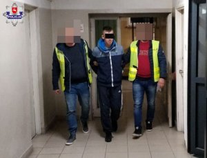 policjanci prowadzą zatrzymanego mężczyznę