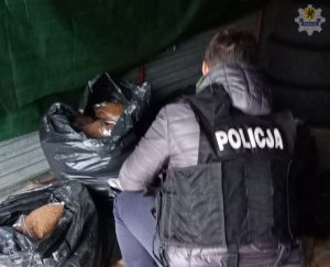 policjant z zabezpieczonym nielegalnym tytoniem
