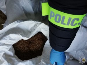 policjant z zabezpieczonym nielegalnym tytoniem
