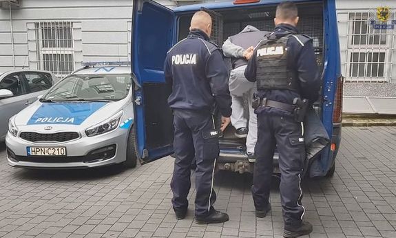 Policjanci prowadzą zatrzymanego