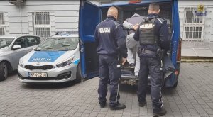 Policjanci prowadzą zatrzymanego